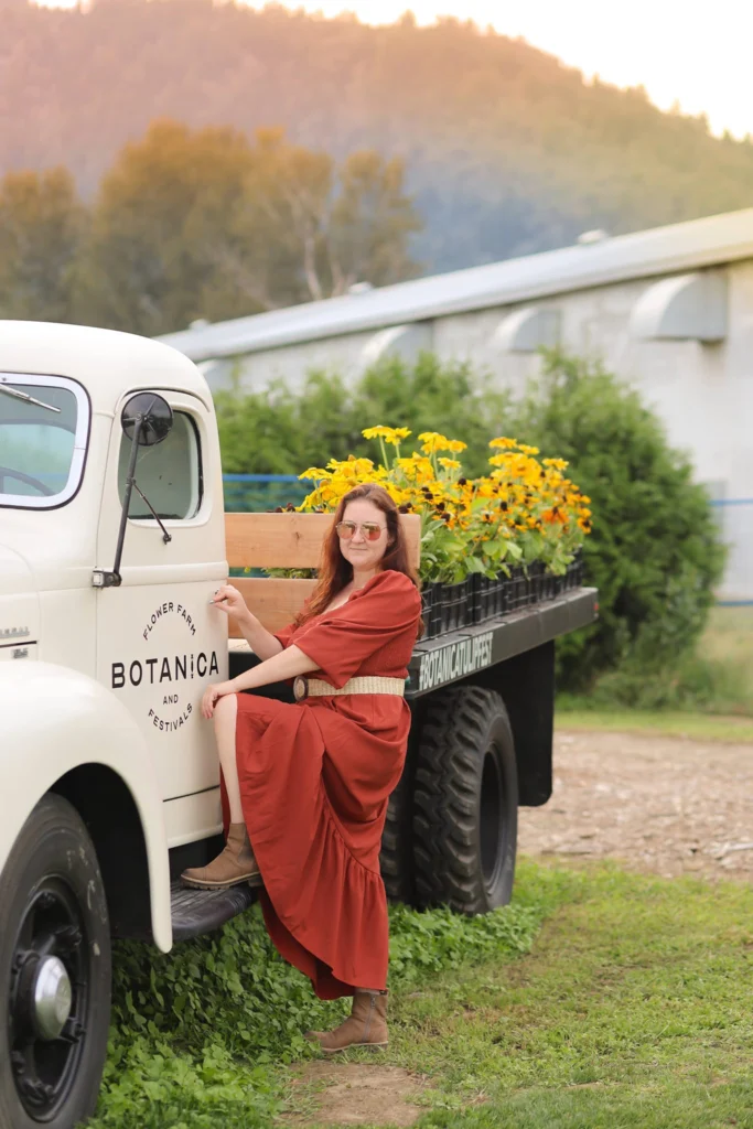 Natalia Vaxman Photographer in Abbotsford BC posing beside a truck with flowers