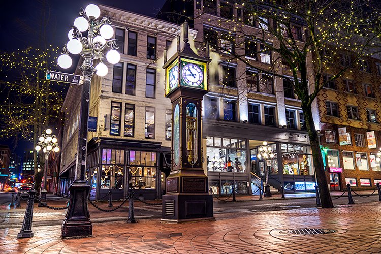 Engagement photo in Gastown with steam clock and string lights.