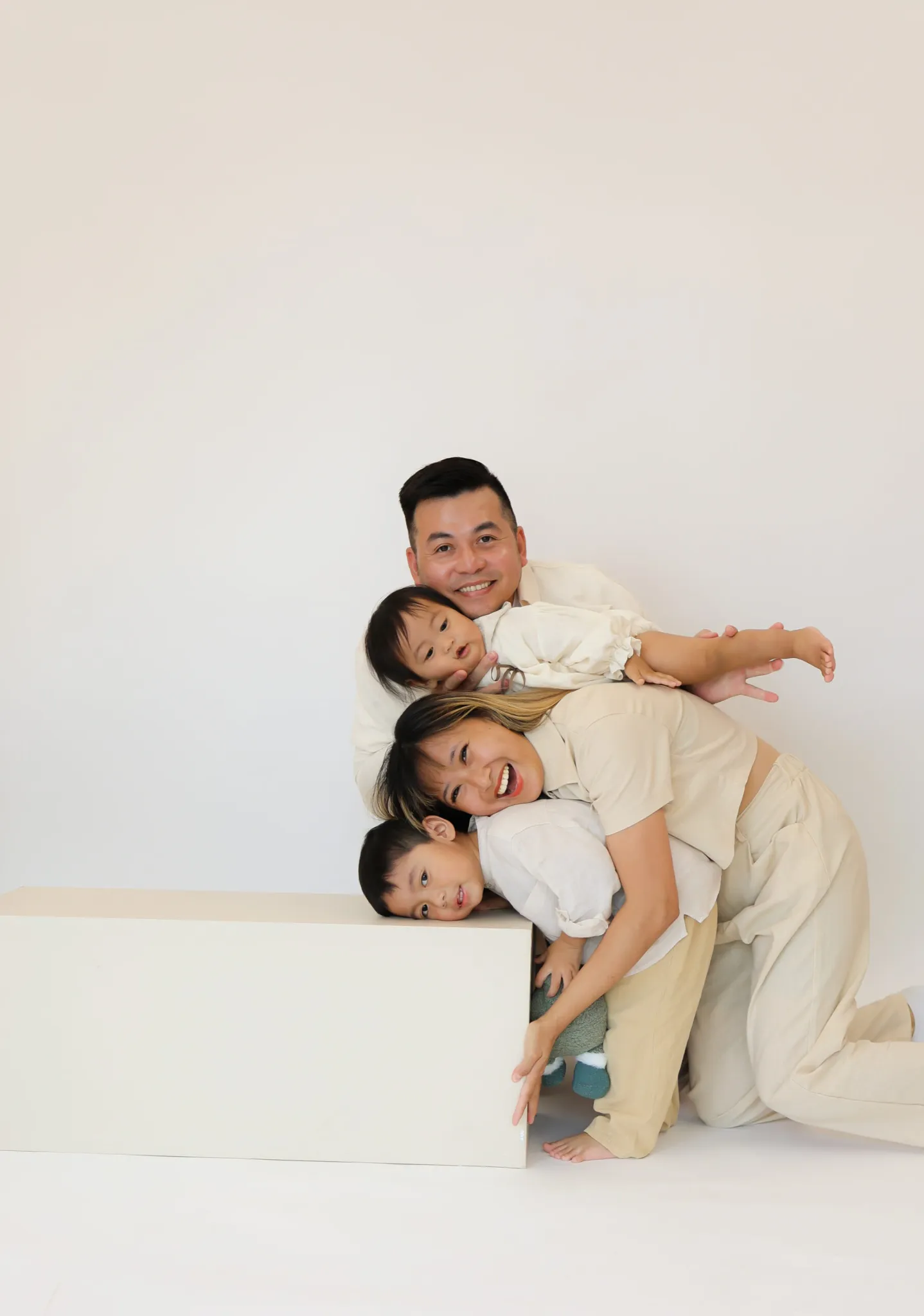 Father lying on floor with children stacked playfully