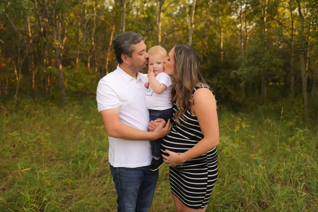 Parents holding baby close during outdoor family portrait