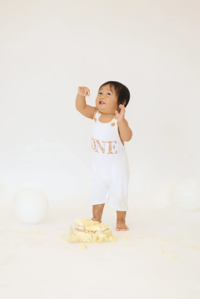 Toddler standing proudly after cake smash session
