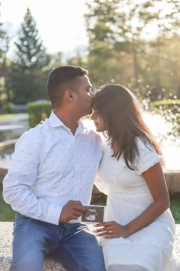 Couple sitting closely together during outdoor engagement and maternity photography session.jpg