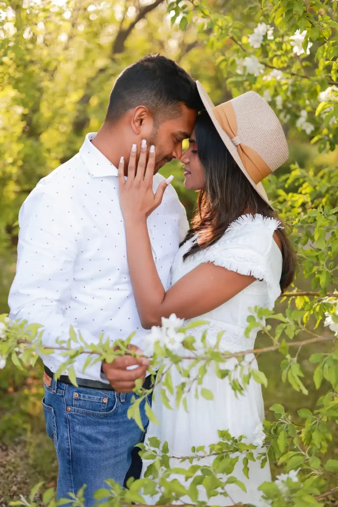 Expecting couple celebrating pregnancy under blooming trees during spring maternity photoshoot.jpg