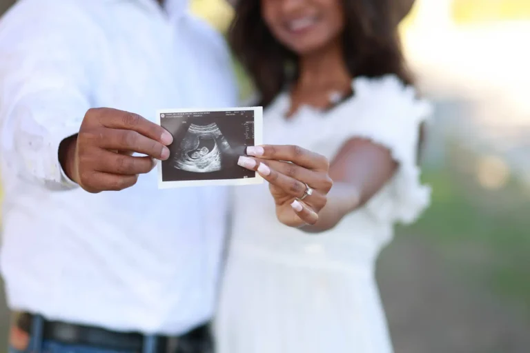 Expecting couple holding ultrasound photo during outdoor maternity photography session.jpg