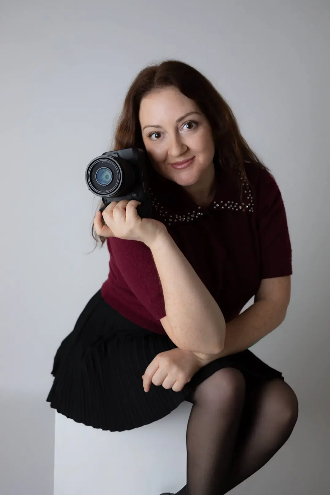 Natalia Vaxman smiling while holding her camera during a personal branding photo session.