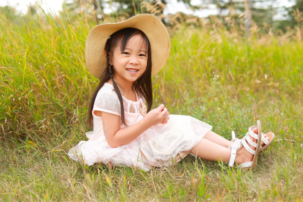 girl sitting grass hat portrait