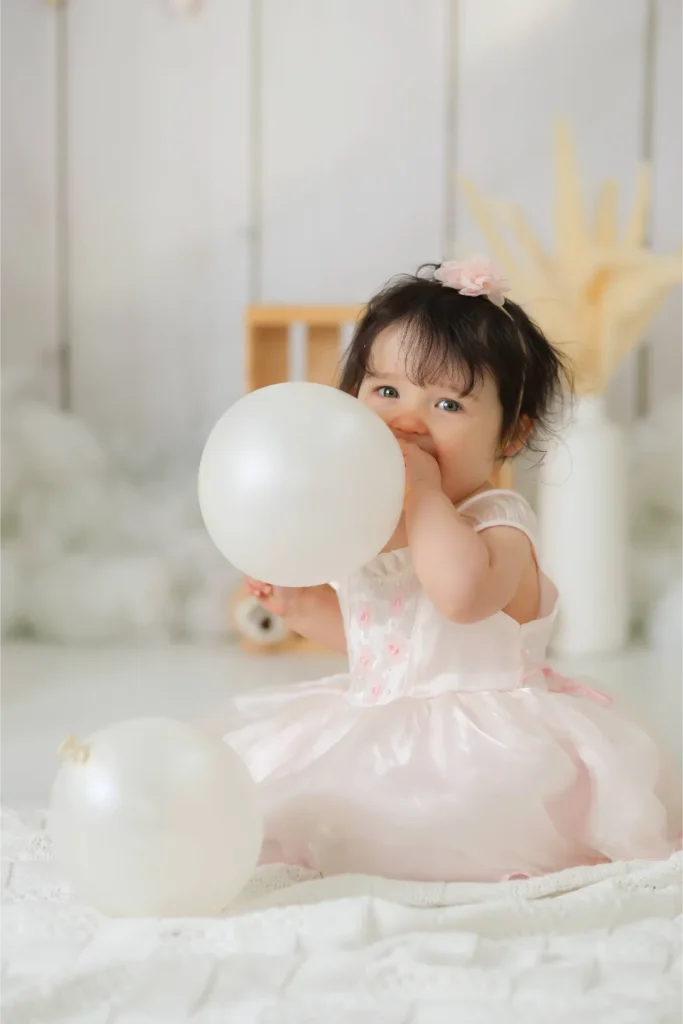 baby girl holding white balloon portrait
