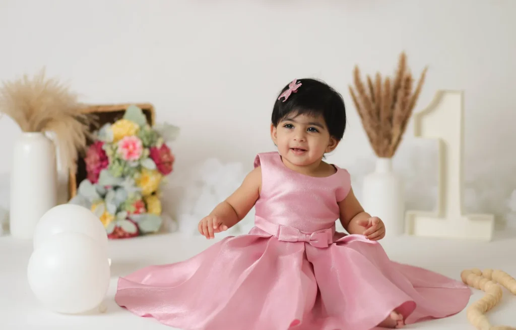 baby girl sitting pink dress studio
