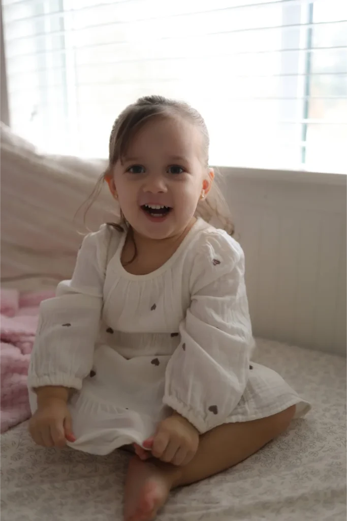 baby sitting on bed natural light portrait