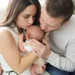 parents holding newborn baby close portrait