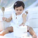 baby sitting white outfit portrait