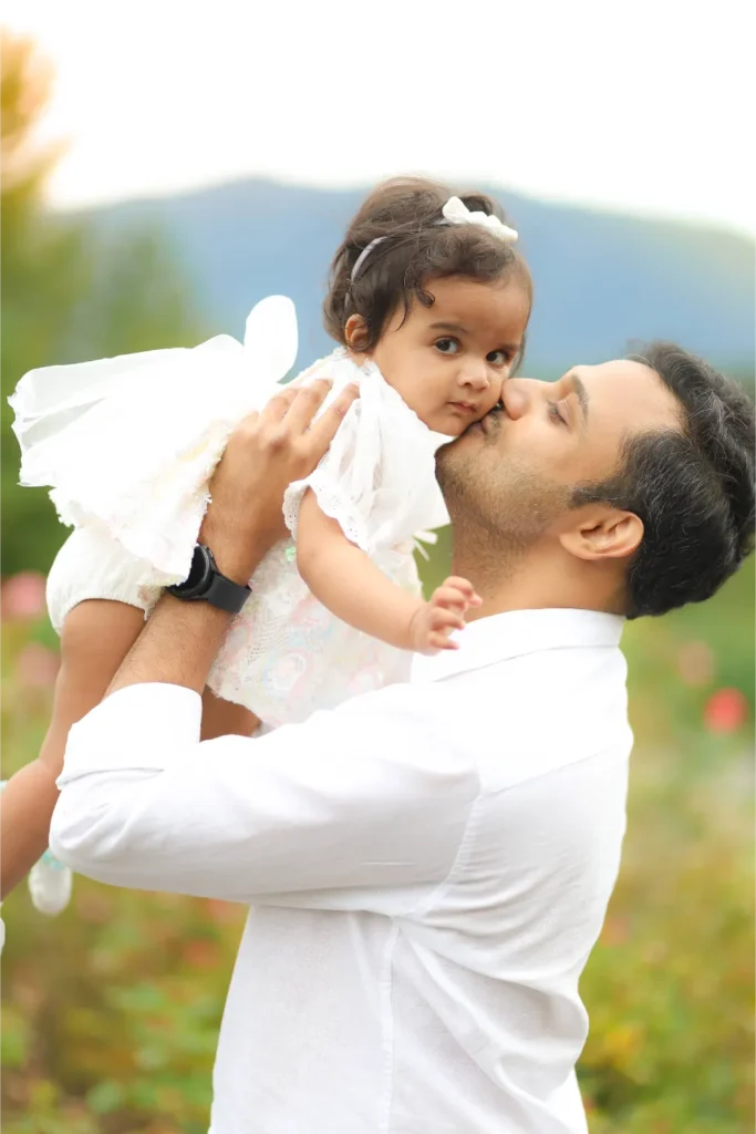 father lifting baby girl outdoor portrait
