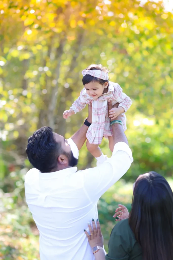 father lifting daughter fall session