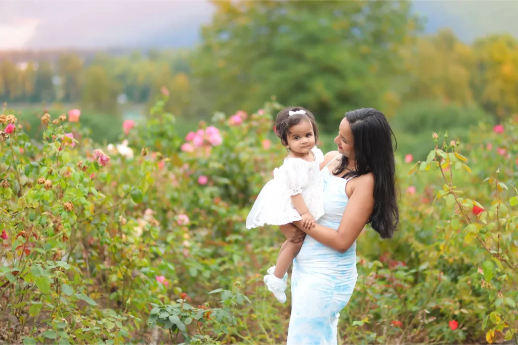 mother holding daughter flower field