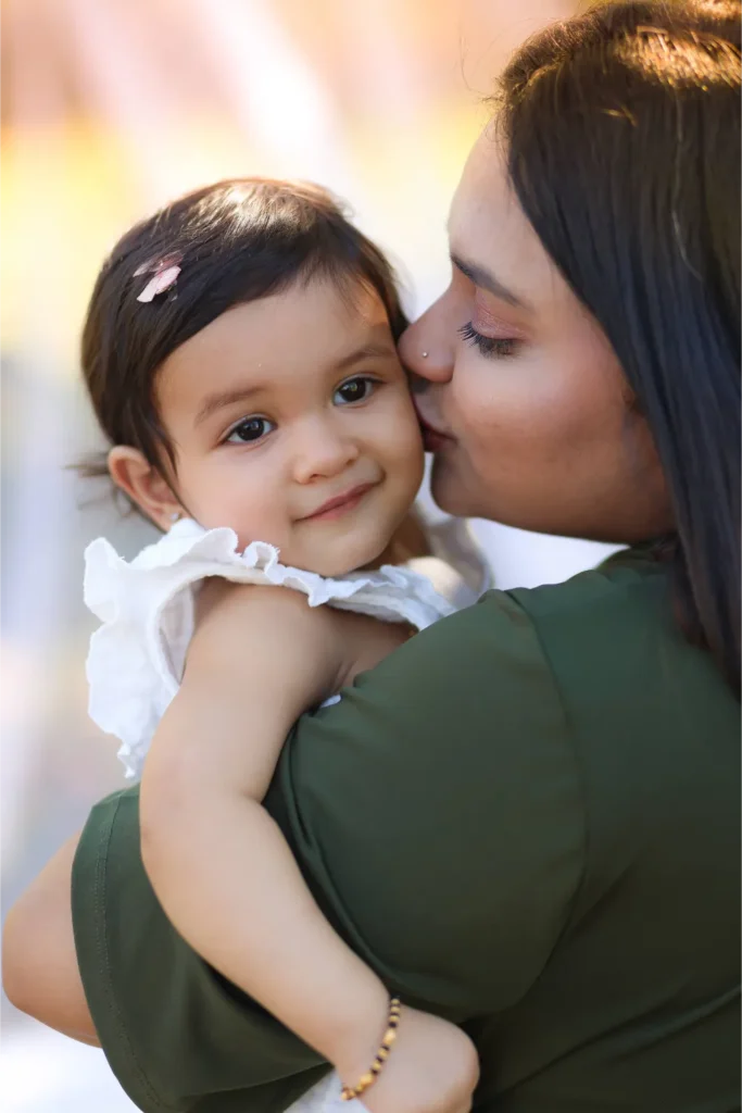 mother kissing baby portrait