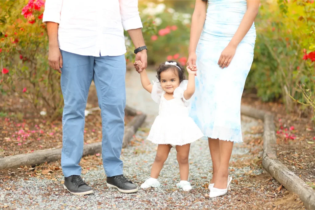 toddler holding parents hands outdoor