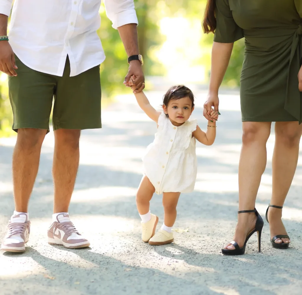 toddler walking between parents
