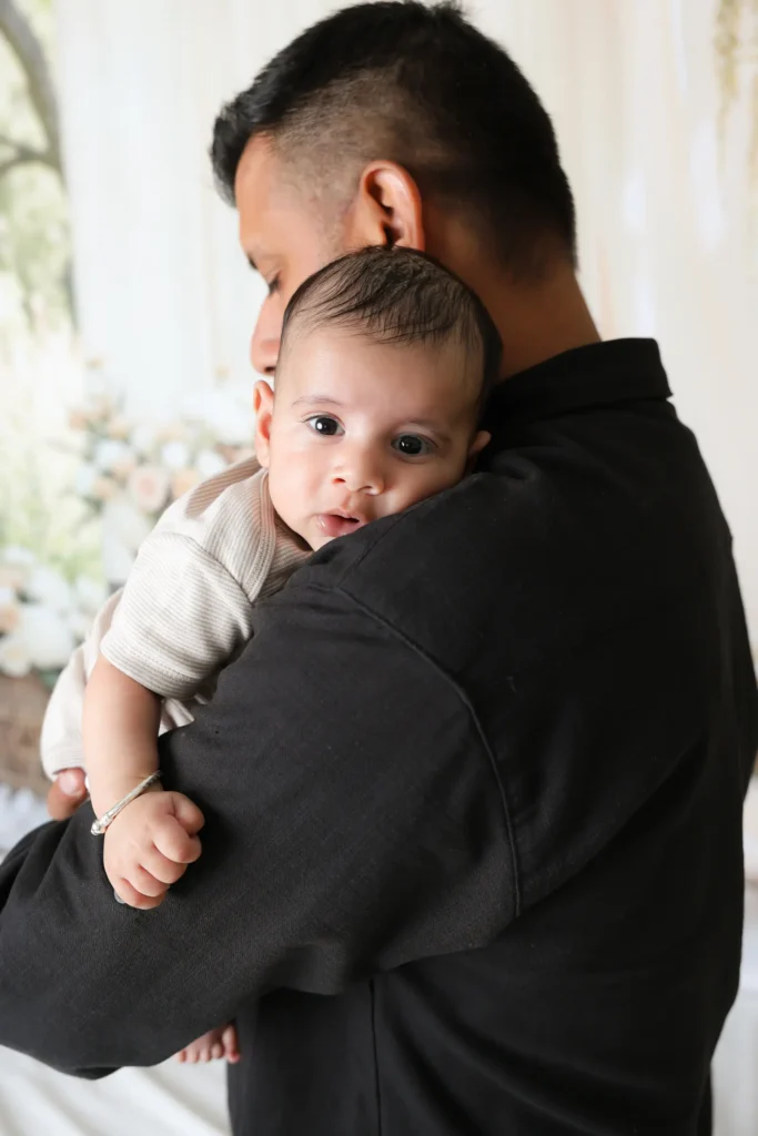 baby looking over dad shoulder