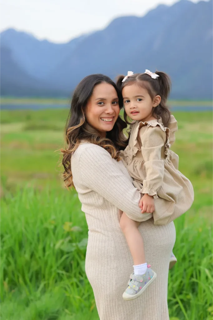 mother holding daughter mountain field