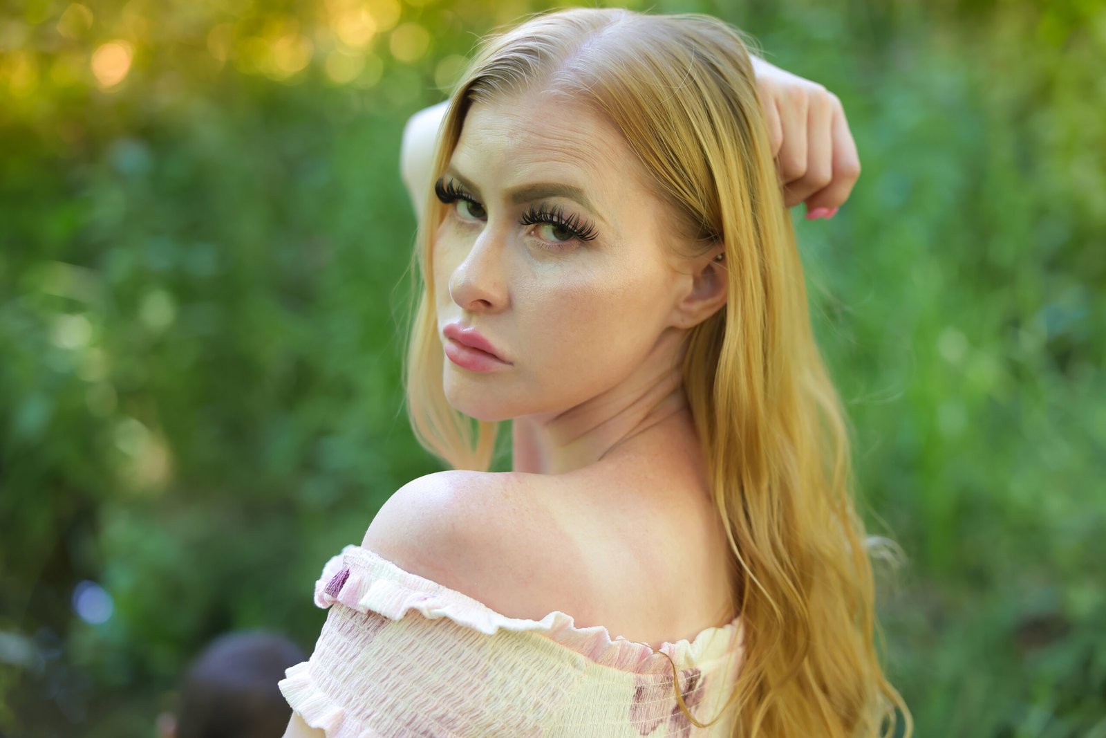 Blonde woman in a pink dress photographed outdoors in soft natural light