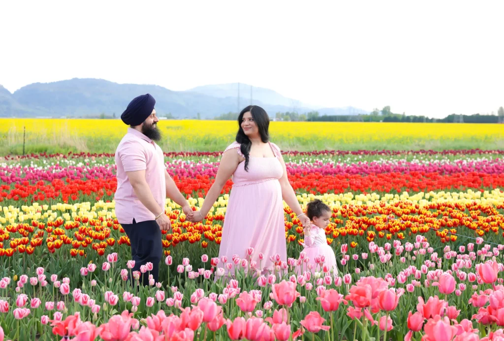 family walking tulip field maternity session