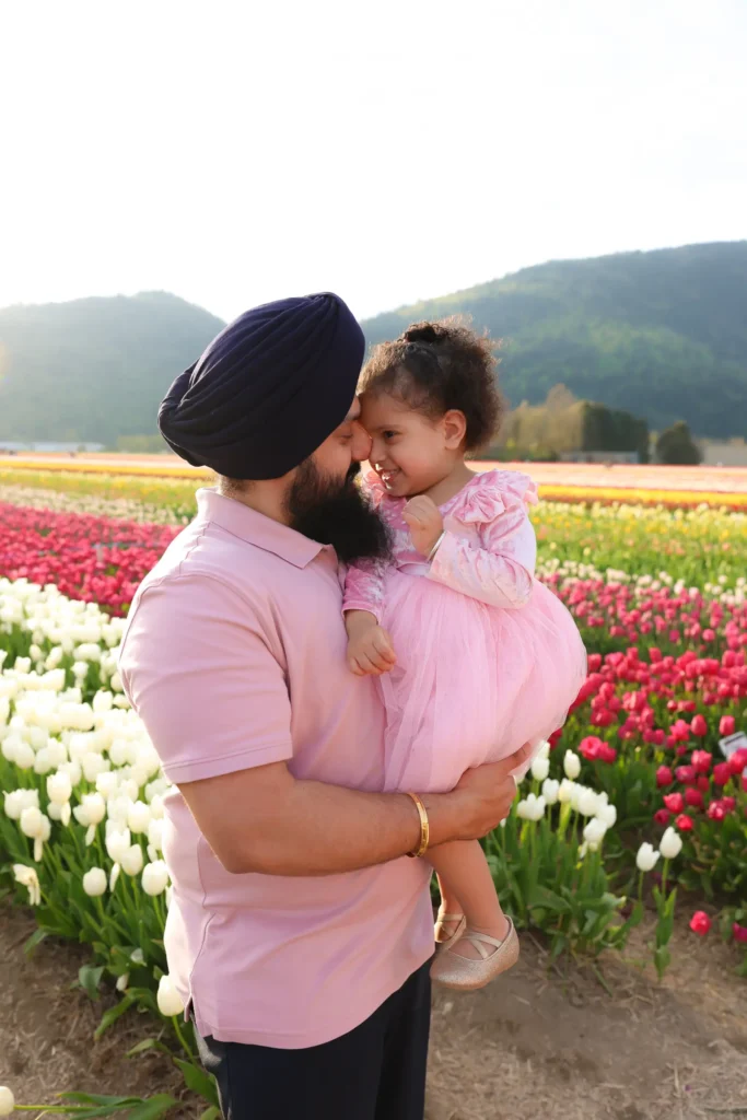 father holding daughter tulip field maternity