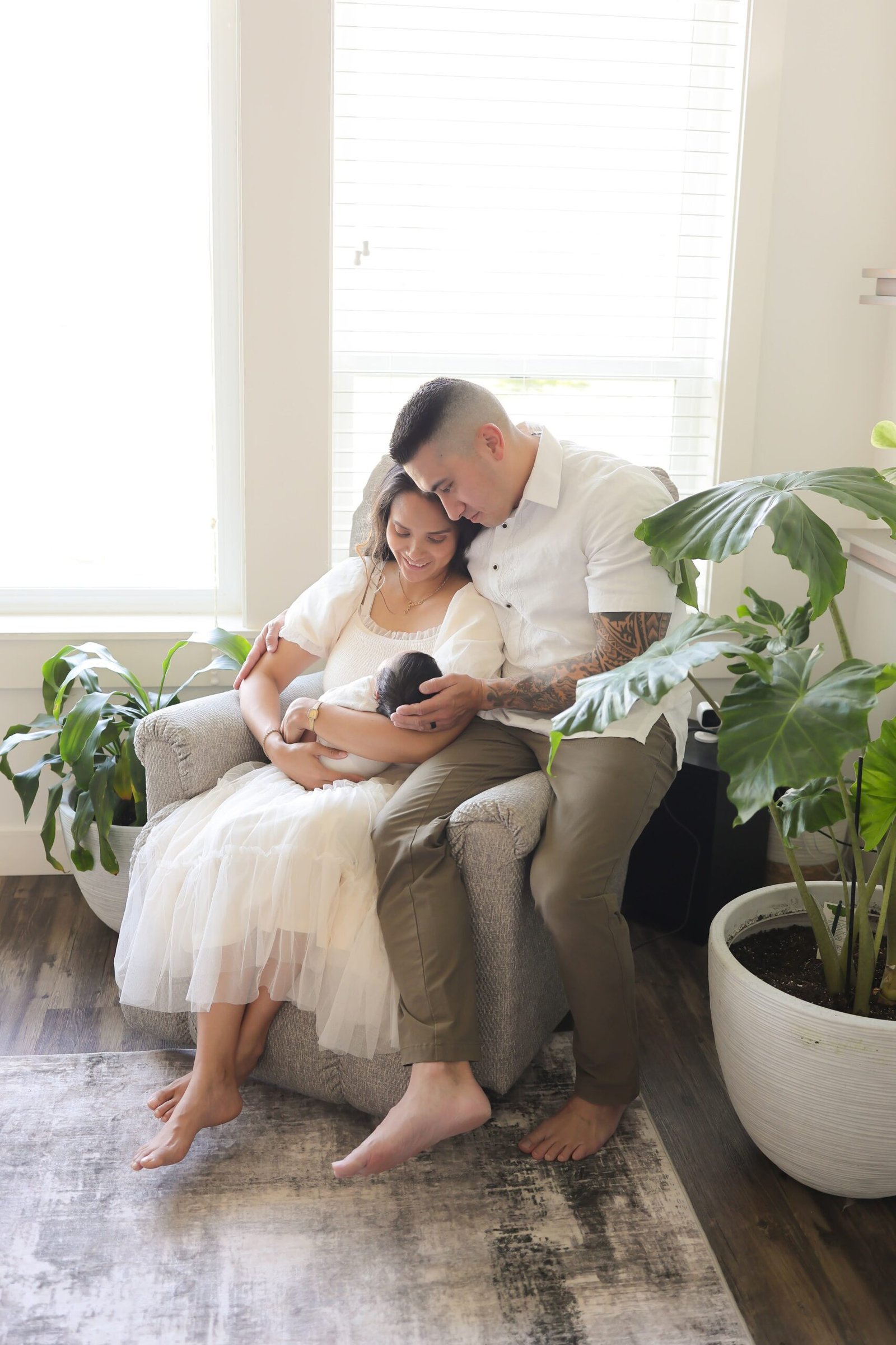 Parents kissing their newborn baby while seated together