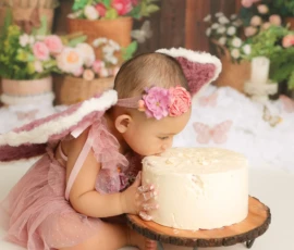 Baby leaning forward to taste cake during cake smash