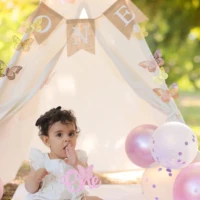 Baby sitting beside balloons in styled setup Baby sitting beside balloons in styled setup
