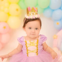 Baby wearing crown sitting in colorful balloon setup Baby wearing crown sitting in colorful balloon setup