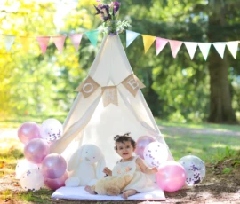 Child playing inside boho teepee with soft blankets