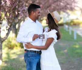 Couple embracing beneath blooming trees during spring portrait Couple embracing beneath blooming trees during spring portrait