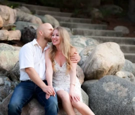 Couple sitting on rocks outdoors smiling together Couple sitting on rocks outdoors smiling together
