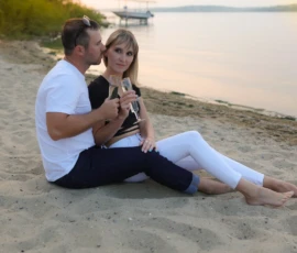 Couple sitting together on beach holding child Couple sitting together on beach holding child