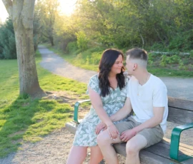 Couple sitting together on park bench holding child Couple sitting together on park bench holding child