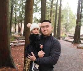 Couple standing together in forest holding baby Couple standing together in forest holding baby