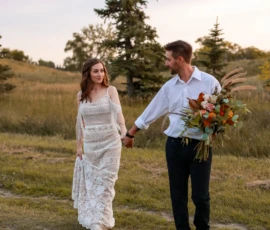 Couple walking together outdoors holding bouquet Couple walking together outdoors holding bouquet