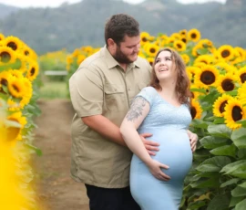 Expecting parents standing together in sunflower field Expecting parents standing together in sunflower field