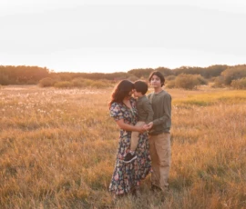 Family embracing closely in golden field at sunset Family embracing closely in golden field at sunset