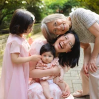 Family gathered closely smiling during outdoor portrait Family gathered closely smiling during outdoor portrait