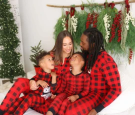 Family sitting on bed with holiday wreath backdrop scaled 1 Family sitting on bed with holiday wreath backdrop scaled 1