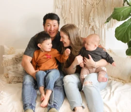 Family sitting together indoors on neutral background Family sitting together indoors on neutral background