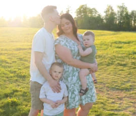 Family standing together in open field at sunset Family standing together in open field at sunset