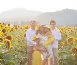 Family standing together in sunflower field Family standing together in sunflower field