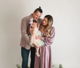 Family standing together indoors holding baby Family standing together indoors holding baby