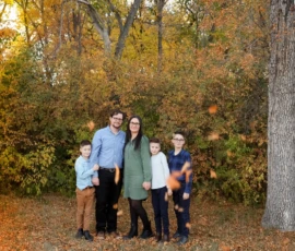 Family standing together outdoors in fall foliage Family standing together outdoors in fall foliage