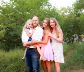 Family standing together outdoors smiling during portrait session Family standing together outdoors smiling during portrait session