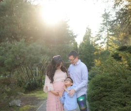 Family standing together outdoors with soft sunlight behind them Family standing together outdoors with soft sunlight behind them