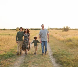 Family walking together along grassy trail Family walking together along grassy trail