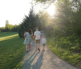 Family walking together down tree lined path Family walking together down tree lined path
